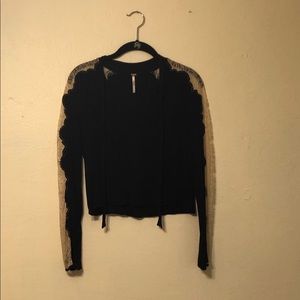 Black blouse with front tie and lace sleeves.